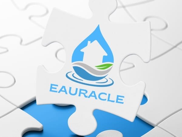 Logo Eauracle sur une pièce de puzzle : goutte d’eau avec maison stylisée, évoquant la valorisation de l’eau de pluie et l’autonomie en eau pour l’habitat.