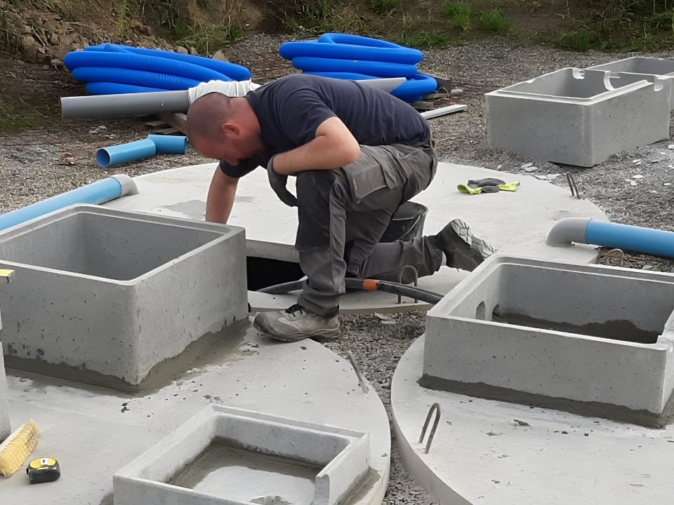 Installation de cuves en béton enterrées pour la récupération et le stockage de l’eau de pluie, avec raccordements techniques sur chantier.