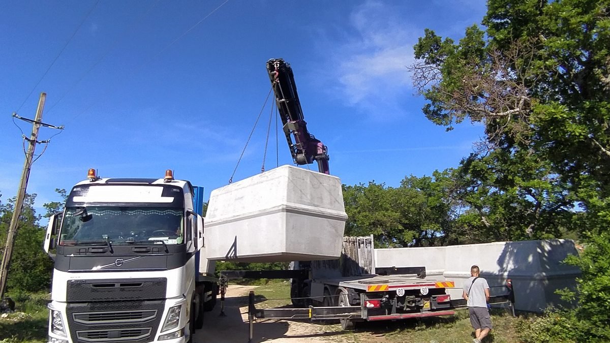 D&eacute;chargement d'une cuve b&eacute;ton par grue depuis le camion