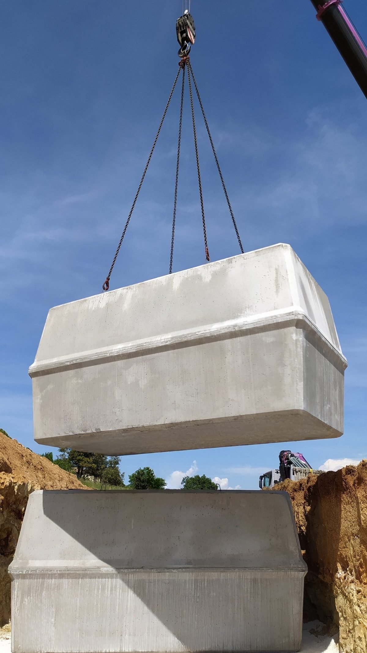 Cuve b&eacute;ton suspendue au-dessus de la tranch&eacute;e avant pose